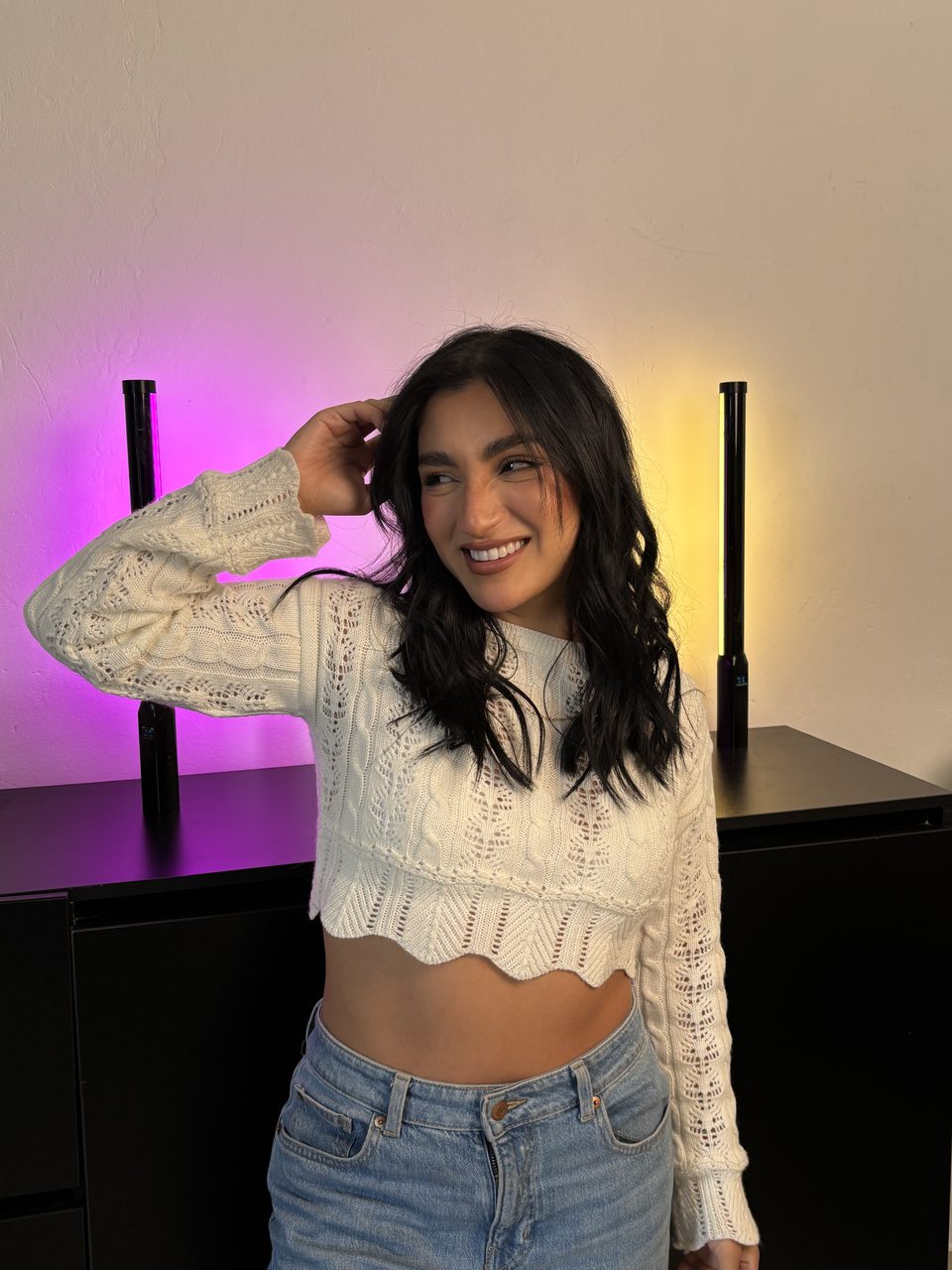 Camila Quiroga sonriendo en una sesión de estudio con luces de color